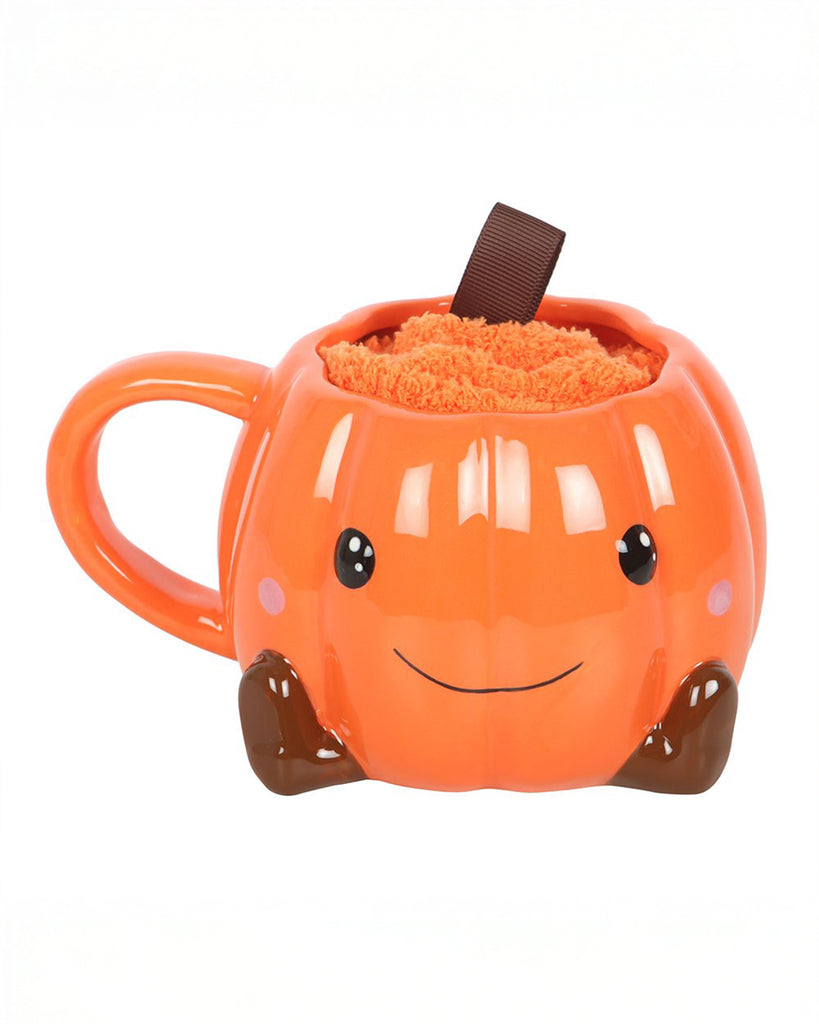 Front-facing Rebel Romance pumpkin mug featuring a smiling face, brown boot details, and fluffy orange socks inside. This cute and practical gift set brings autumn vibes and spooky charm to your hot drink routine.