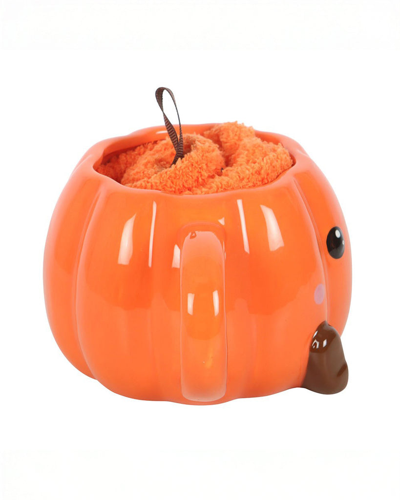 Side view of the Rebel Romance pumpkin mug filled with rolled fluffy socks and topped with a brown ribbon to look like a pumpkin stalk. The perfect cosy combo for chilly autumn evenings and spooky season fun.