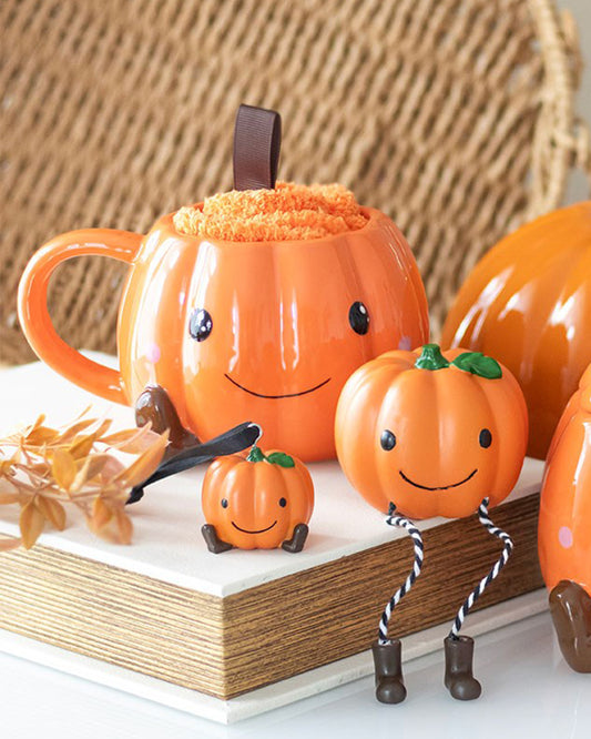 Cute Halloween-themed pumpkin mug and cosy orange socks from Rebel Romance, styled with mini pumpkin decorations and autumn leaves. A perfect autumnal gift set for spooky season lovers who enjoy hot chocolate in adorable ceramic mugs.