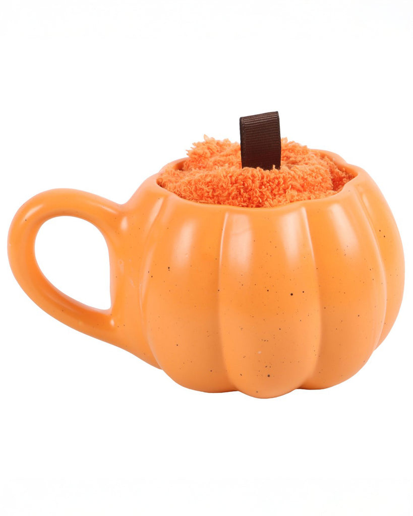 Side-angle shot of the Rebel Romance Pumpkin Mug filled with fluffy socks and topped with a ribbon loop resembling a pumpkin stalk.