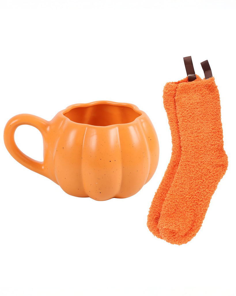 Orange pumpkin-shaped mug and matching fluffy socks with brown ribbon stems laid out side by side. A cosy autumn gift set by Rebel Romance.