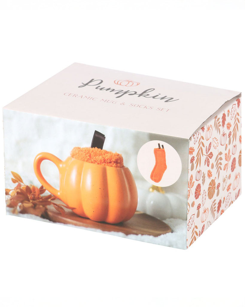 Packaged Pumpkin Mug and Socks Set by Rebel Romance, featuring an orange ceramic mug with fuzzy socks inside. The box has autumn leaves and pumpkin graphics, perfect for gifting.