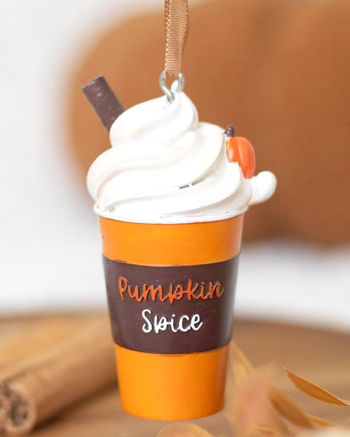 Pumpkin Spice Latte hanging ornament from Rebel Romance, shaped like an orange and brown takeaway cup with whipped cream, a cinnamon stick, and a tiny pumpkin. Features the words “Pumpkin Spice” written on the front and a satin ribbon loop for easy hanging. A cosy, quirky seasonal decoration for autumn or Halloween lovers from a small UK brand that celebrates alternative style and festive fun.