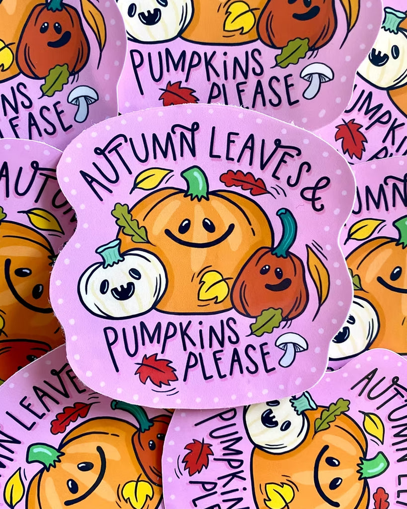 A pile of adorable gloss vinyl stickers shaped like pumpkins with smiling faces, autumn leaves, and mushrooms, on a pink polka dot background. The text on each sticker reads “Autumn Leaves & Pumpkins Please”. Designed by Yasmin Cousins and stocked at Rebel Romance, a small UK business celebrating alternative style, spooky-cute art, and millennial nostalgia with illustrated accessories, cards, jewellery and more.