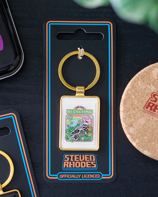 Packaged Rebel Romance enamel keyring featuring Steven Rhodes’ “Learn About Recycling” retro artwork. Presented on branded card backing, the gold rectangular keyring shows a skeleton surrounded by plants, flowers and a gravestone. Unique eco-gothic gift idea for alternative millennials.