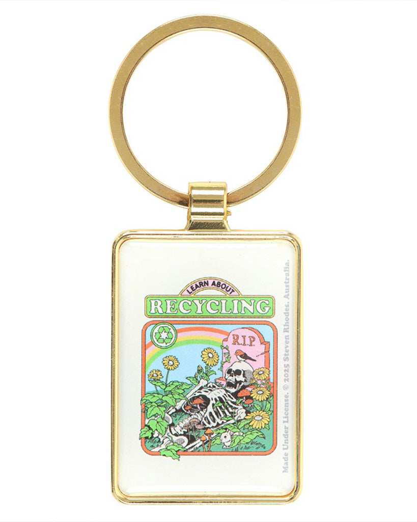 Back view of the Rebel Romance “Learn About Recycling” keyring by Steven Rhodes. The gold rectangular enamel keyring shows a skeleton in a garden scene with sunflowers, mushrooms, rainbow and “RIP” gravestone. Fun and gothic eco accessory for alternative fashion lovers.