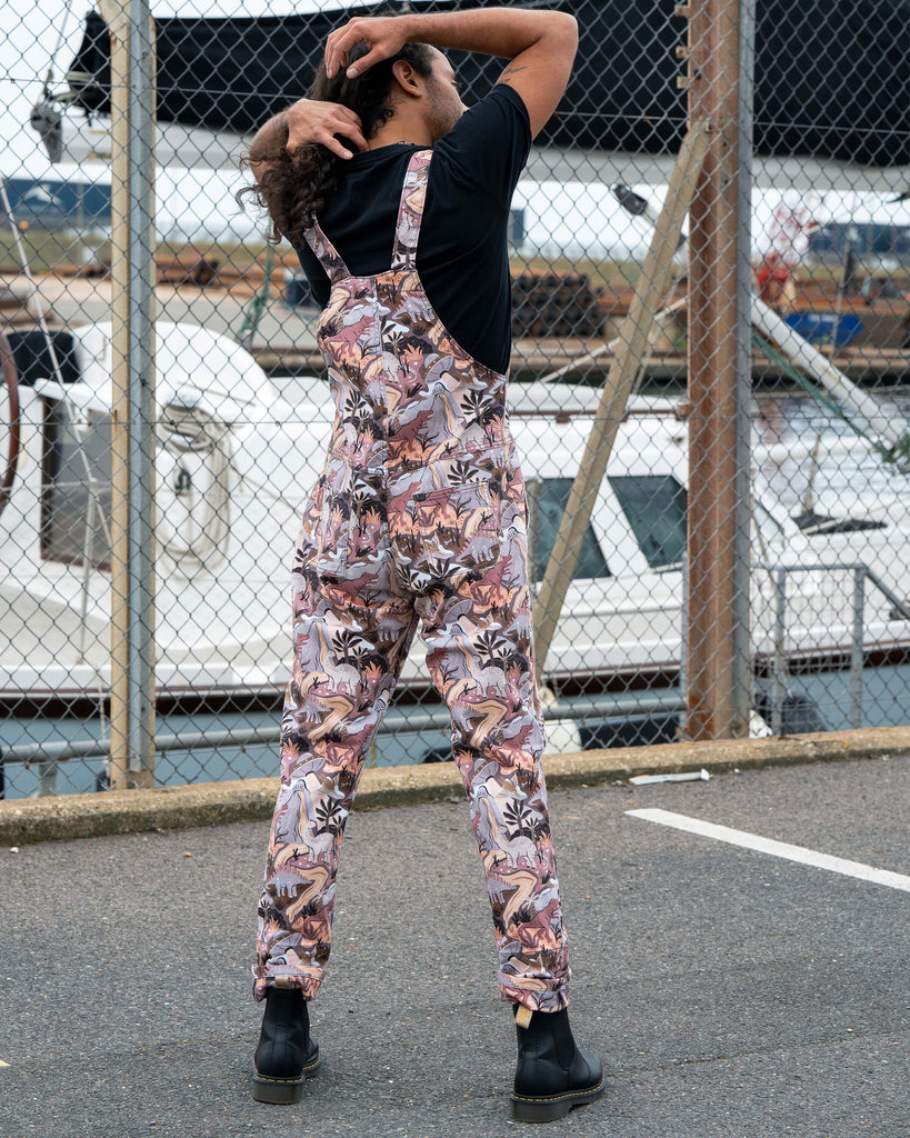 Rear view of Richard in Rebel Romance Dinoverse Dungarees, showing adjustable straps and detailed dinosaur pattern across the back.