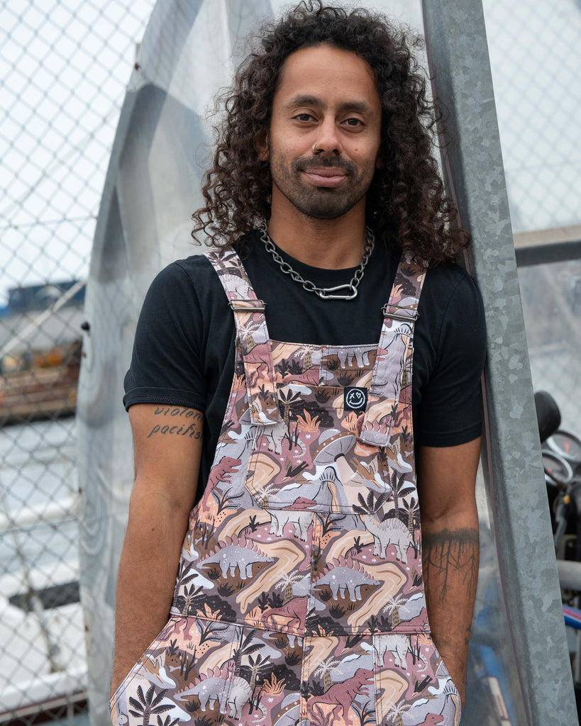 Close-up of Richard wearing Rebel Romance Dinoverse Dungarees, highlighting the colourful prehistoric pattern on stretch twill fabric.