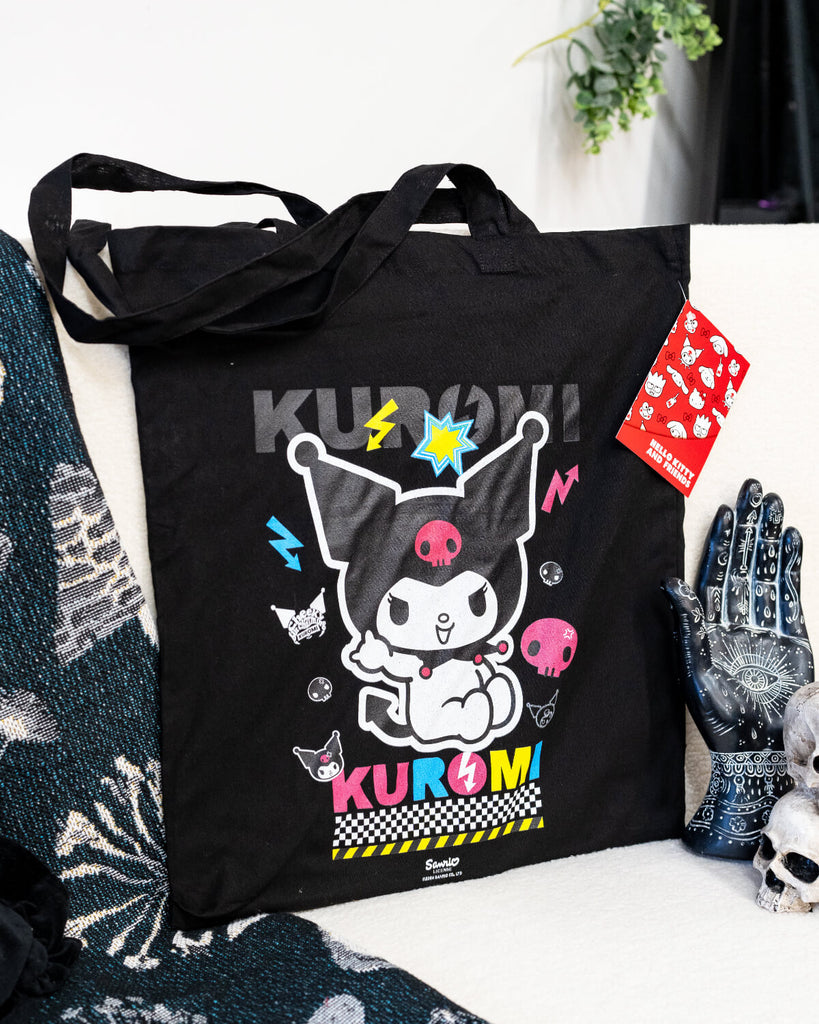 A black tote bag featuring Sanrio’s Kuromi in a colourful design with neon pink, blue, and yellow accents. The bag showcases Kuromi surrounded by lightning bolts, skulls, and fun punk-style details. Perfect for anime fans and alternative fashion lovers.
