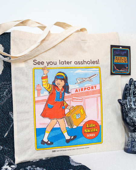 A natural cotton tote bag featuring Steven Rhodes’ “See You Later” retro artwork from the Life Skills Series. The design shows a girl in a red dress waving goodbye at an airport with a cheeky text overlay. The bag is practical and stylish, with long handles and bold colours, perfect for fans of quirky and edgy art styles.