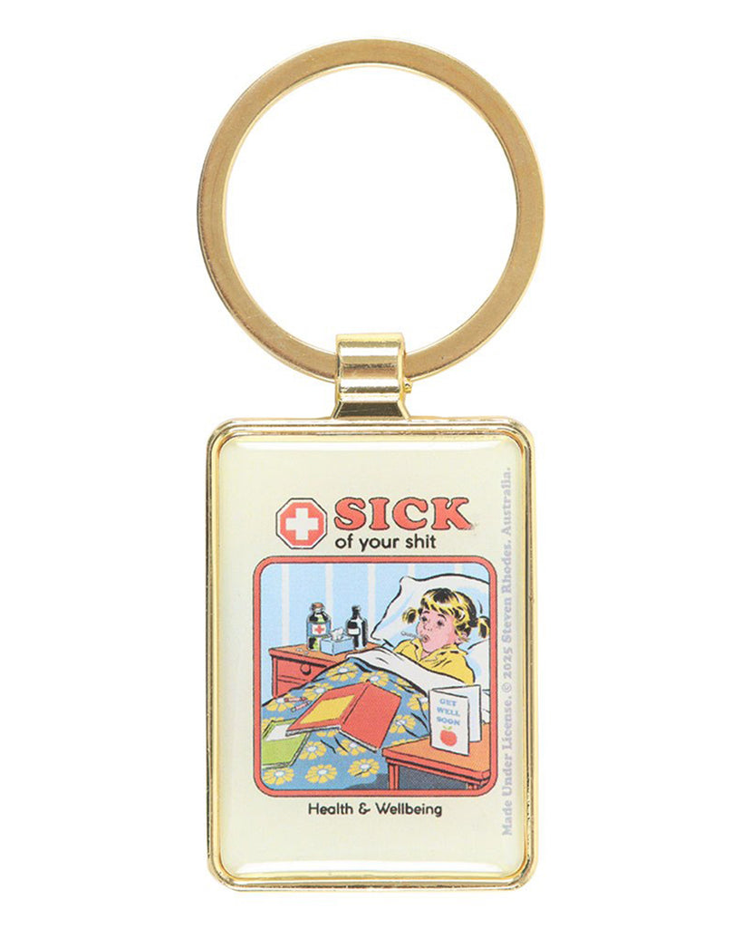 Front view of Steven Rhodes “Sick of your shit” enamel keyring with gold frame. The retro art design features a sick child in bed and sarcastic text. A quirky and funny gift available from Rebel Romance, UK alternative fashion and gift brand.