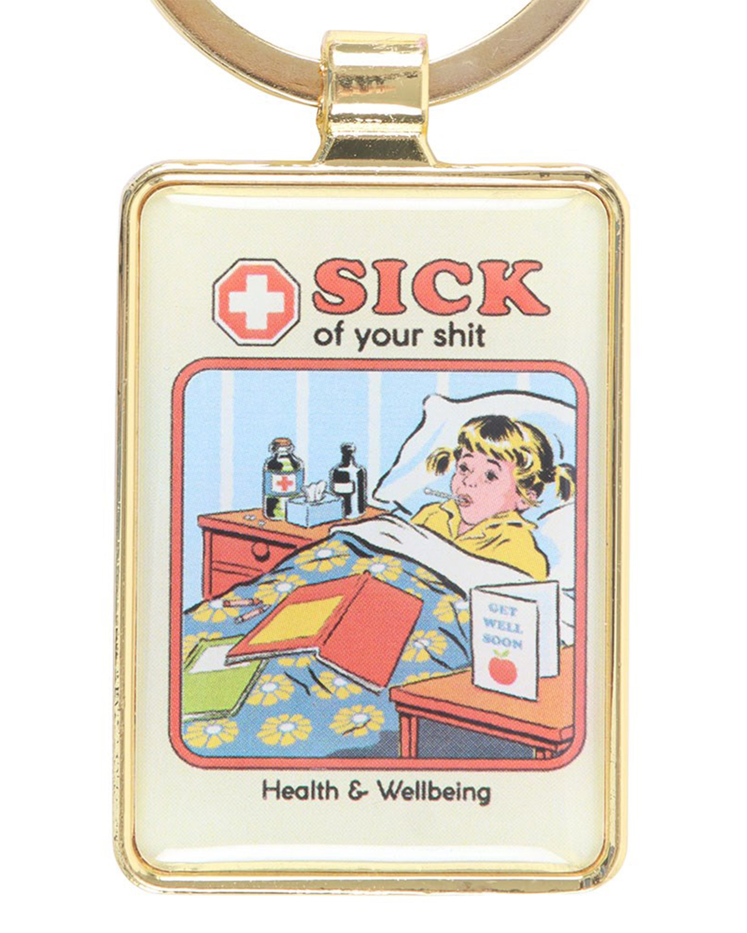 Rectangular enamel keyring with gold trim featuring Steven Rhodes’ retro comic art. It shows a sick child in bed with the bold text “Sick of your shit – Health & Wellbeing.” Sold by Rebel Romance, a UK brand for alternative fashion, homeware and gifts.