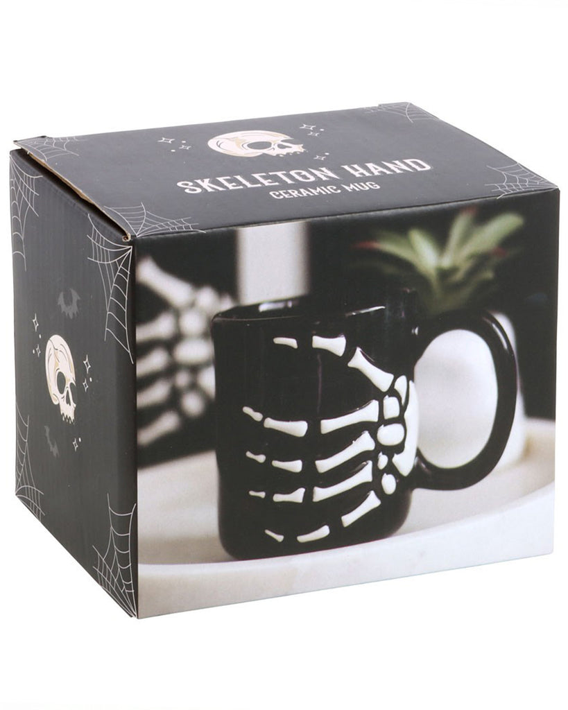 Skeleton Hand Ceramic Mug product packaging with skulls and spiderwebs design, showing the mug as a gothic gift option.