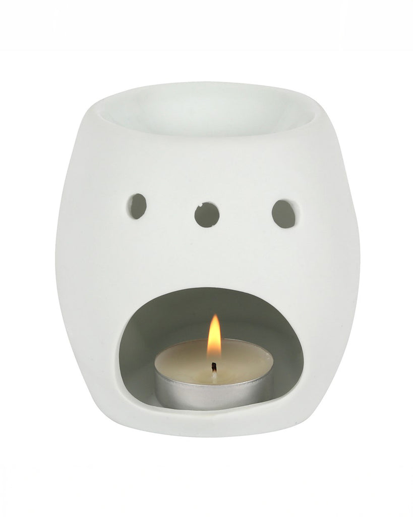 Rear view of the White Skull Oil Burner, showing the tealight cavity with a lit candle inside. Circular ventilation holes allow the warm light to glow through.