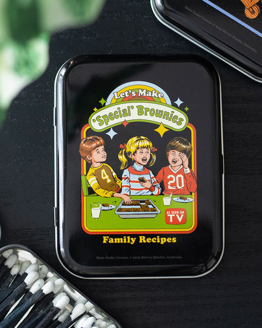 Styled product photo of the Rebel Romance “Let’s Make Special Brownies” Steven Rhodes stash tin. Retro-inspired metal storage tin with colourful cheeky artwork, perfect for hiding herbs, sweets, or treasures. A fun and unique alternative homeware gift for millennials who love quirky design.
