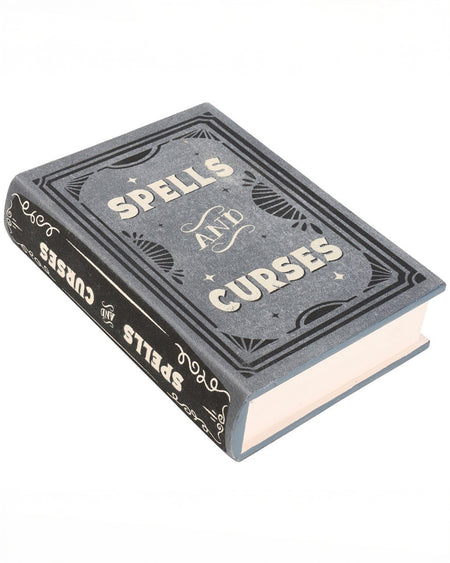 A close-up of the Spells and Curses Book Shaped Storage Box stocked by the alternative gift store, Rebel Romance, styled to resemble an antique spellbook. The grey cover features gothic detailing with the words "Spells and Curses" in bold, vintage typography.