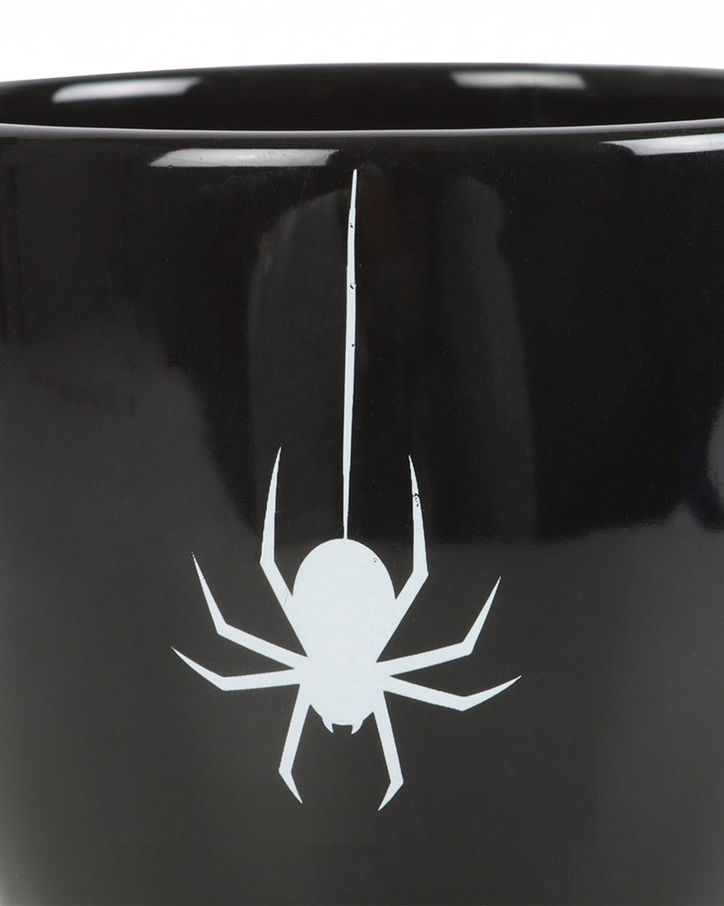 Close-up of the white spider print design on the front of the gothic-style black teacup.
