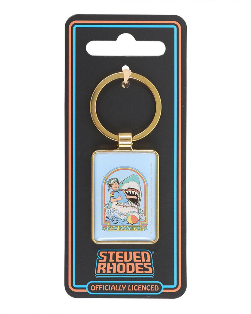 Rebel Romance Steven Rhodes Stay Positive enamel keyring displayed on official packaging. Retro humour snorkeller and shark artwork in gold frame. Officially licensed Steven Rhodes accessory for quirky alternative style lovers.