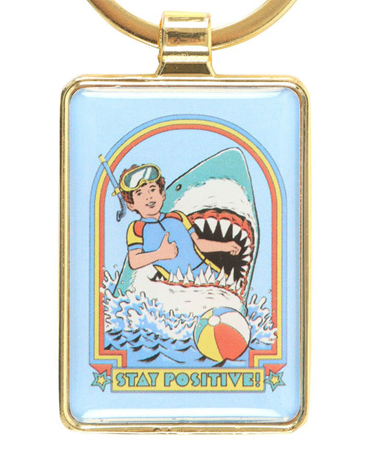 Rebel Romance Steven Rhodes Stay Positive keyring featuring a retro snorkeller giving a thumbs up while being attacked by a shark. Fun, dark humour enamel design with a gold frame. Perfect alternative gift for millennials who love quirky accessories.