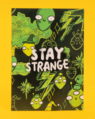 A dark green and neon A6 postcard featuring a group of quirky green aliens, stars, and lightning bolts with the bold text “Stay Strange” in white. Designed by Katie Abey, this playful and eccentric card is ideal for millennials into alternative humour, quirky stationery, and embracing their inner weirdo.