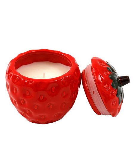 A ceramic strawberry-shaped candle pot with a realistic textured design, featuring a removable lid with green leaves and a brown stem. The candle inside is creamy white, and the pot adds a fruity, vintage charm. Sold from Rebel Romance, a UK business celebrating alternative aesthetics.