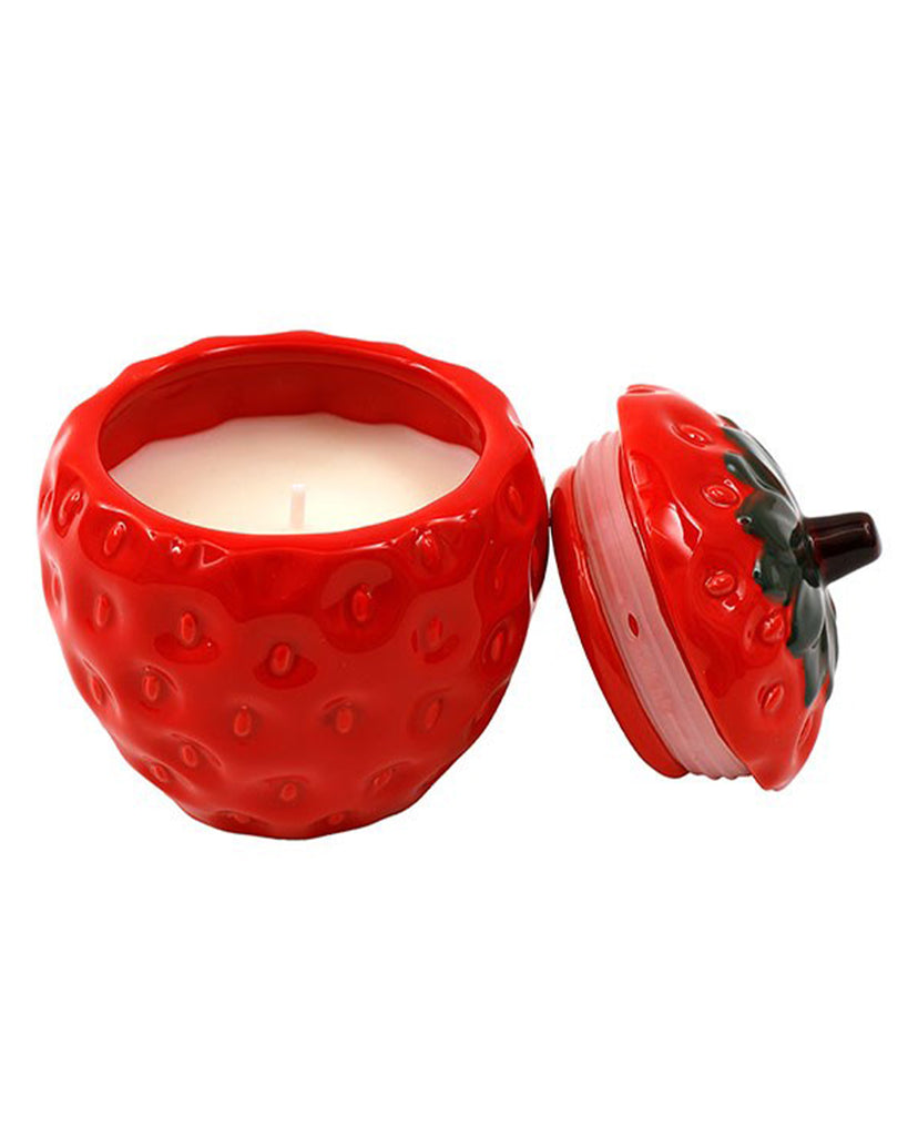 A ceramic strawberry-shaped candle pot with a realistic textured design, featuring a removable lid with green leaves and a brown stem. The candle inside is creamy white, and the pot adds a fruity, vintage charm. Sold from Rebel Romance, a UK business celebrating alternative aesthetics.