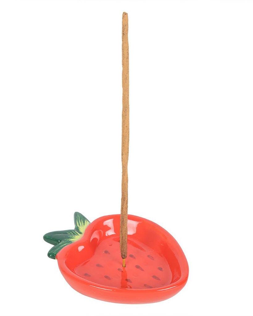 The incense holder in use, with a burning incense stick placed upright in the centre hole. The curved dish catches falling ash, making it both stylish and practical.