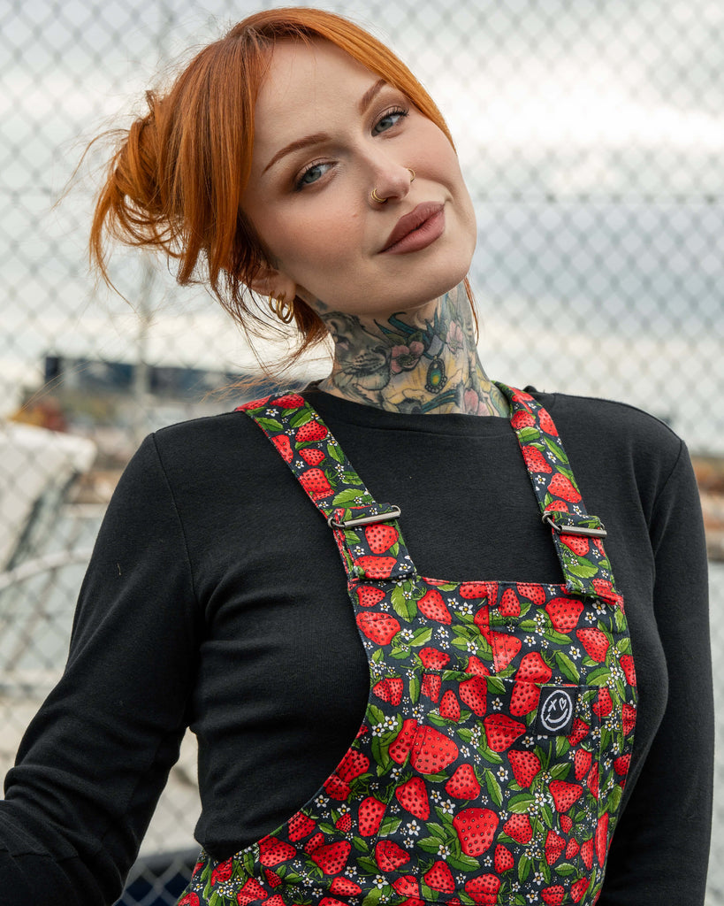 Erin models Rebel Romance Strawberry Field dungarees with a playful all-over strawberry print. Adjustable straps, stretch twill fabric, and a flattering slim fit design.