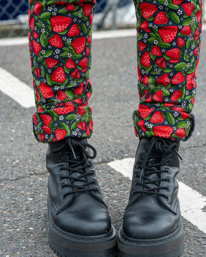 Detail shot of the Strawberry Field dungarees by Rebel Romance, focusing on the rolled hems paired with chunky black lace-up boots for a statement alt style.