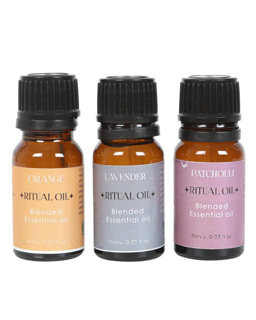 Close-up of three 10ml amber glass bottles of essential oils with pastel-coloured labels indicating Patchouli, Lavender, and Orange scents.