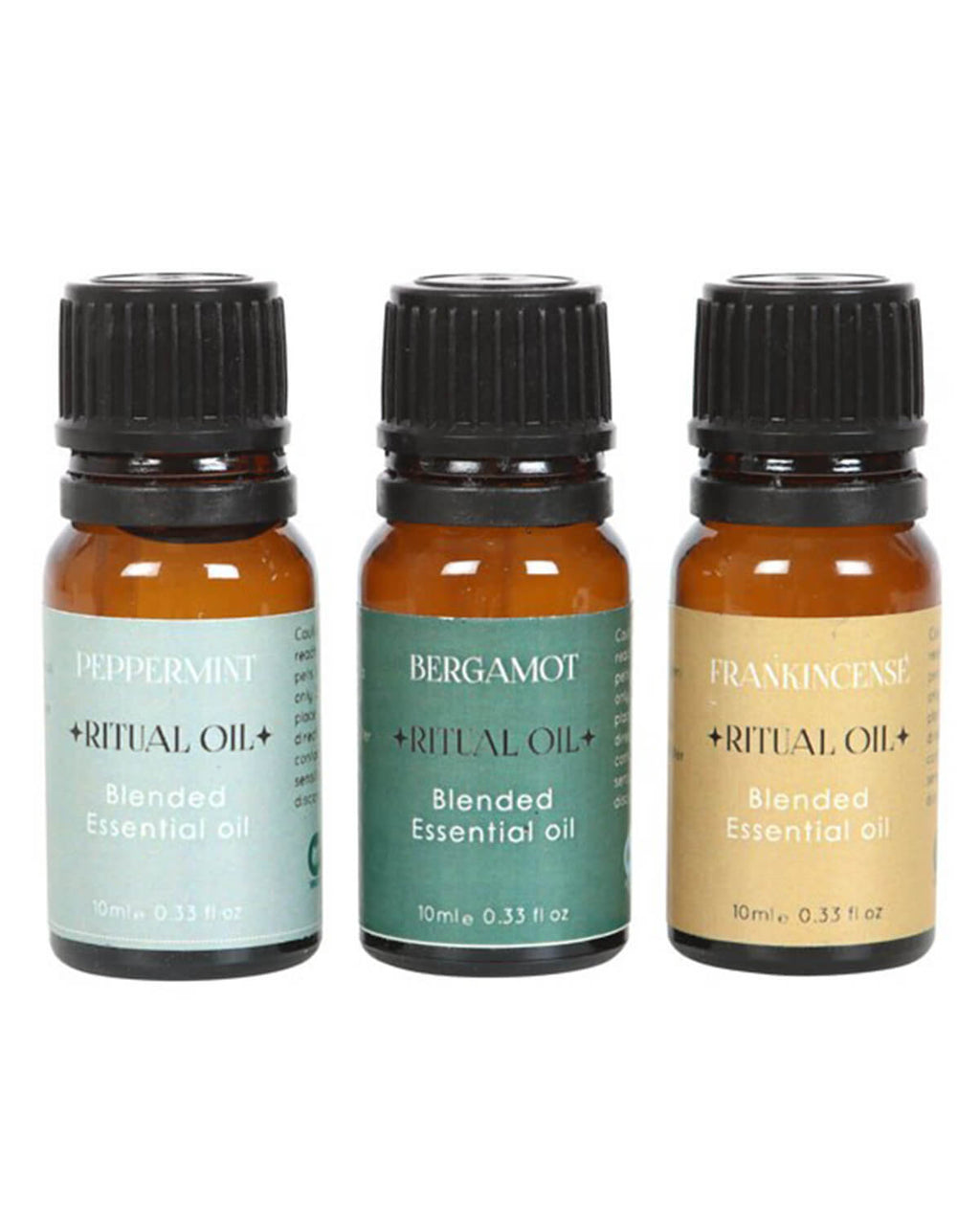 Three amber glass bottles of Success Ritual essential oils, labeled Peppermint, Bergamot, and Frankincense, with pastel green, teal, and beige labels, standing upright in a row.