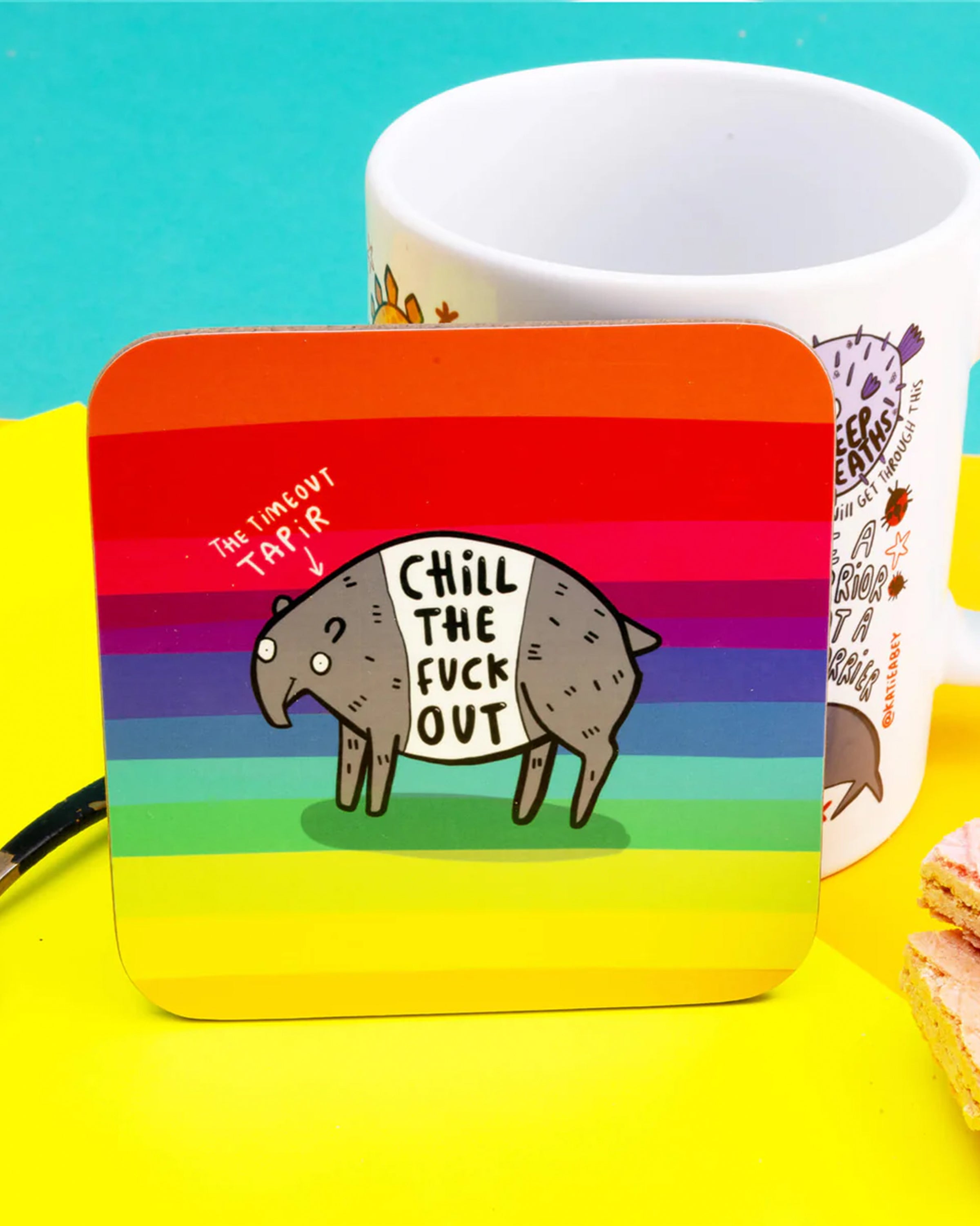 A colourful Katie Abey coaster sold by Rebel Romance, featuring a rainbow striped background and a cute illustrated tapir with the bold phrase “Chill The Fuck Out.” A fun, alternative gift idea for millennials who love quirky homeware with humour.