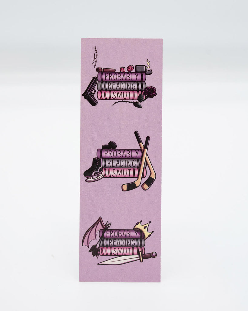 Back of the My TBR is Full of Trigger Warnings Bookmark showing stacks of books labelled “Probably Reading Smut” with themed icons like hockey sticks, swords, dice, and a bat wing. A cheeky, alternative gift for spicy romance fans and bookish goths.