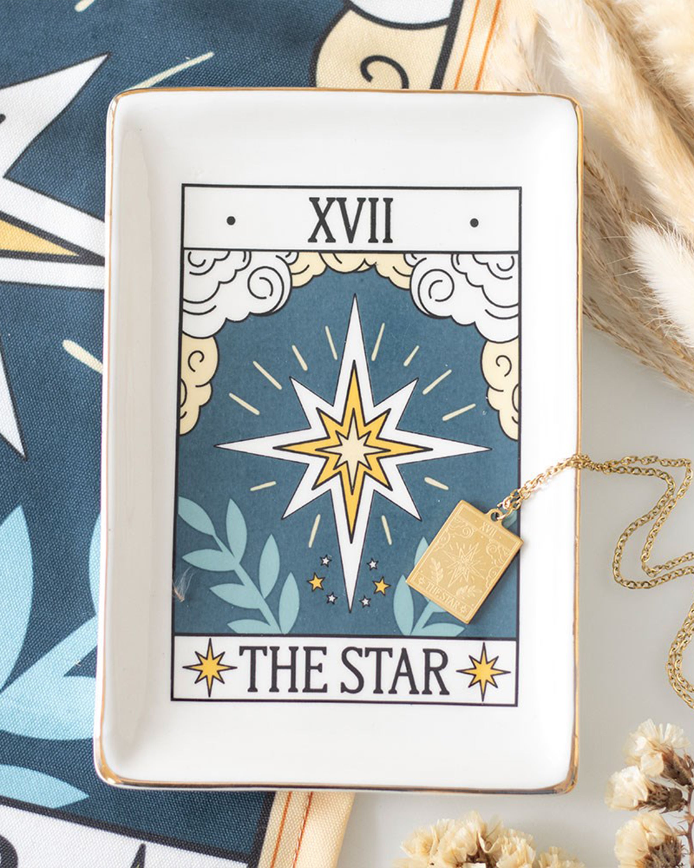 A styled scene featuring the Rebel Romance The Star tarot ceramic trinket dish holding a gold necklace. The mystical design with gold edging adds a magical touch to home décor while keeping jewellery and treasures safe.