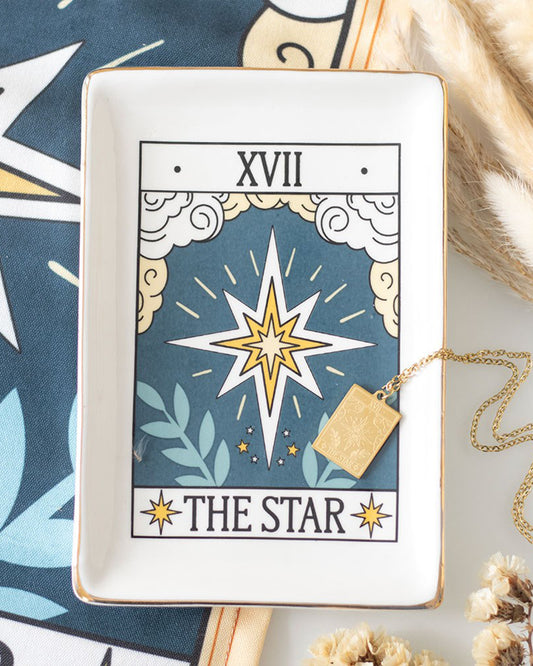 A styled scene featuring the Rebel Romance The Star tarot ceramic trinket dish holding a gold necklace. The mystical design with gold edging adds a magical touch to home décor while keeping jewellery and treasures safe.