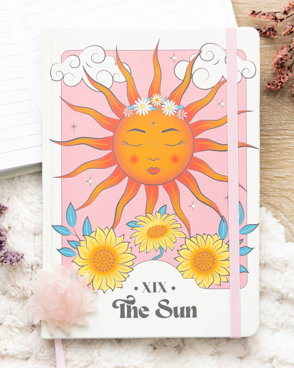 Front view of The Sun Celestial A5 Notebook – The notebook cover showcases a radiant sun with closed eyes, glowing cheeks, and sunflower details at the bottom. The words “XIX The Sun” are written in a bold, vintage-style font.