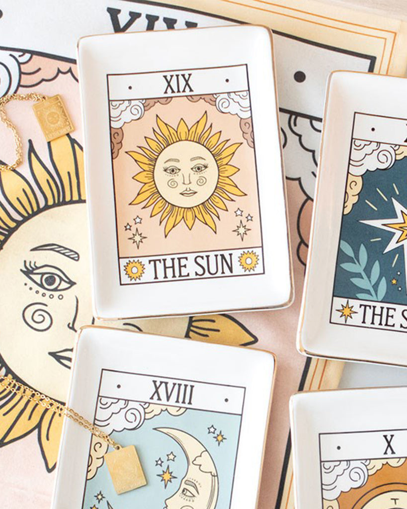 A rectangular ceramic trinket dish by Rebel Romance featuring The Sun tarot card design with gold edging. Perfect for jewellery or small treasures, styled with matching moon and star dishes on a mystical flatlay.
