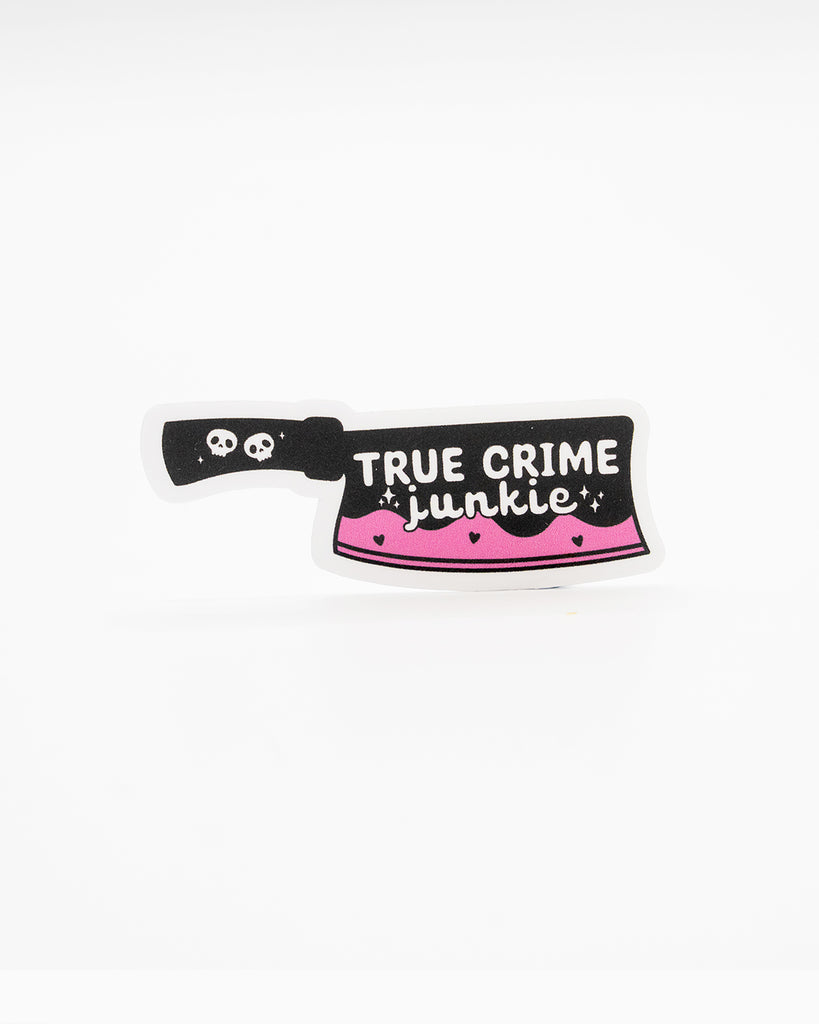 Edgy die-cut vinyl sticker shaped like a cleaver with a black handle and pink dripping blade. Features the phrase “True Crime Junkie” in white lettering, decorated with skulls, hearts, and sparkles. Perfect for fans of true crime and spooky aesthetics. Designed by Rebel Romance, a small UK brand known for alternative fashion, slow style, and quirky millennial-friendly gifts.