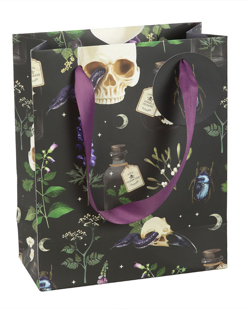 Side view of the Rebel Romance Medium Venom & Vines Gift Bag, showing both the beetle tag and the gothic botanical print with skulls, plants, and poison bottles on a black background.