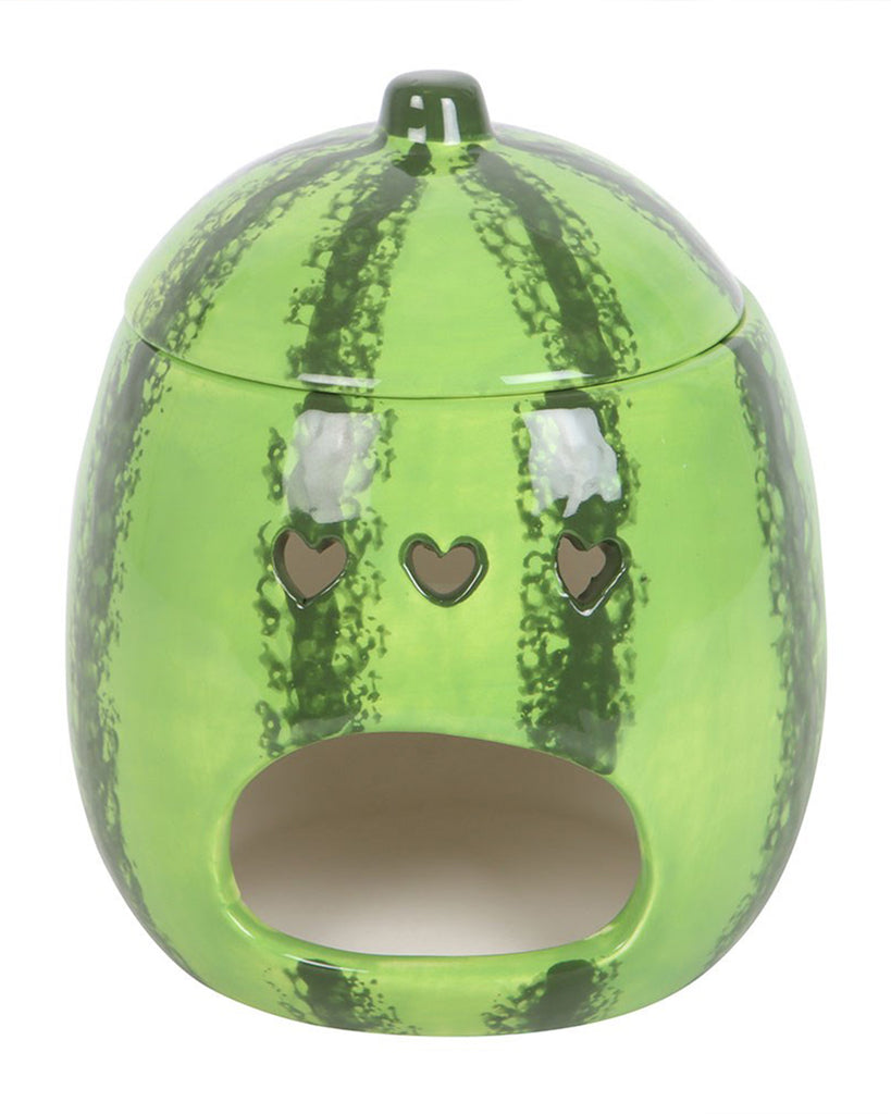 A glossy ceramic oil burner shaped like a watermelon, featuring a vibrant green rind with dark stripes and a small stem-like lid. The front has an open section for a tealight candle and three heart-shaped cutouts above it, allowing light to shine through. This quirky and functional home accessory is perfect for diffusing wax melts or fragrance oils while doubling as a fun fruit-themed decor piece.