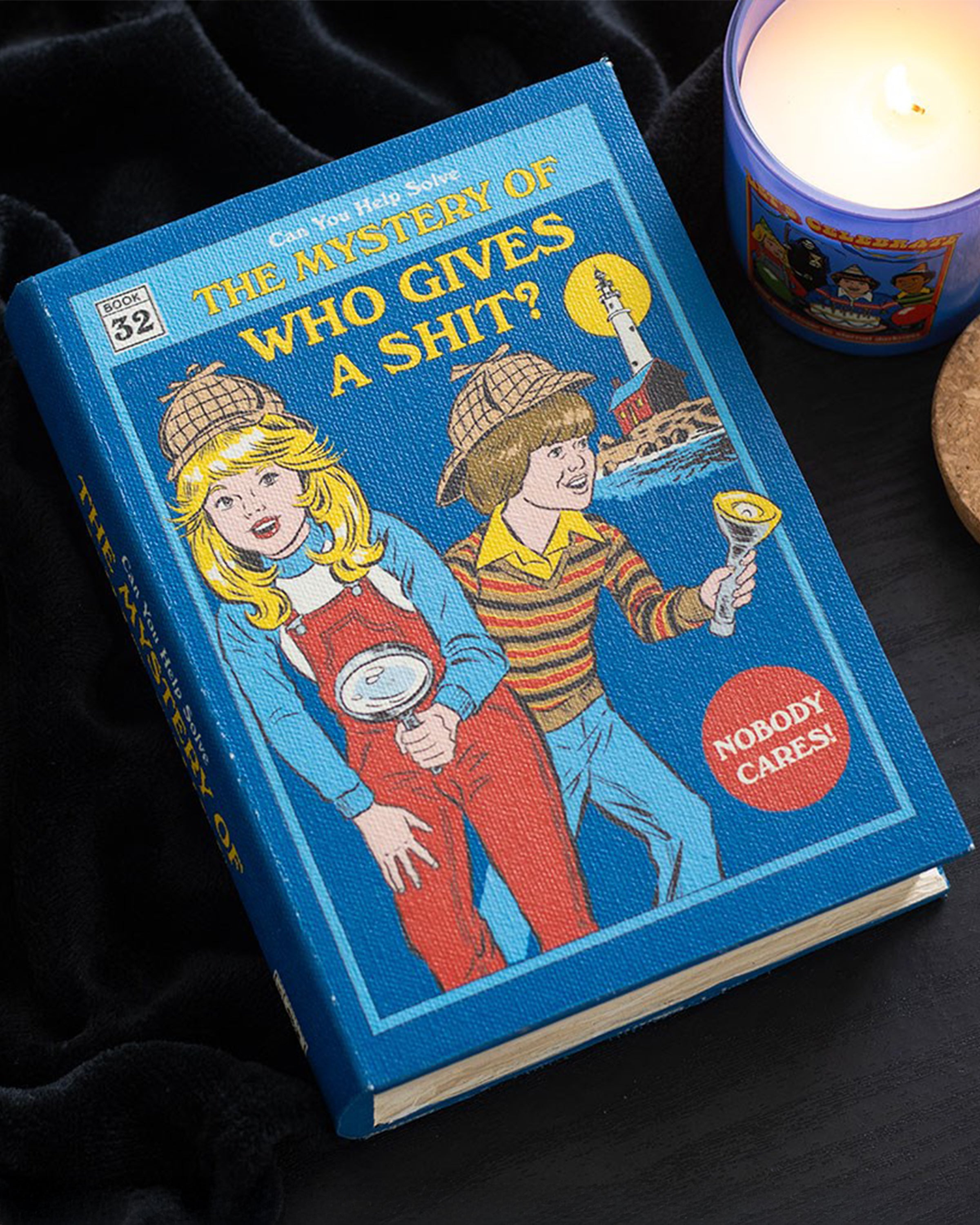 Book titled 'The Mystery of Who Gives a Shit?' with Steven Rhodes illustration of two children and a candle in the background.