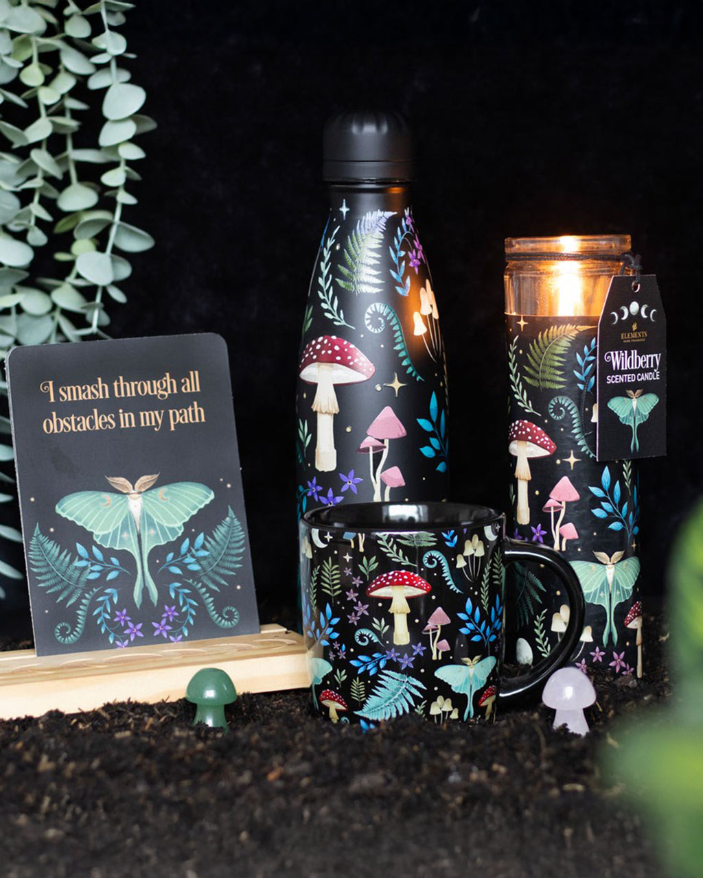 A Dark Forest Wildberry tube candle from Rebel Romance, featuring a mystical forest print with toadstools, ferns, and a luminous luna moth on a black background. The glass-encased candle has a dark, enchanted aesthetic, perfect for gothic or witchy décor.