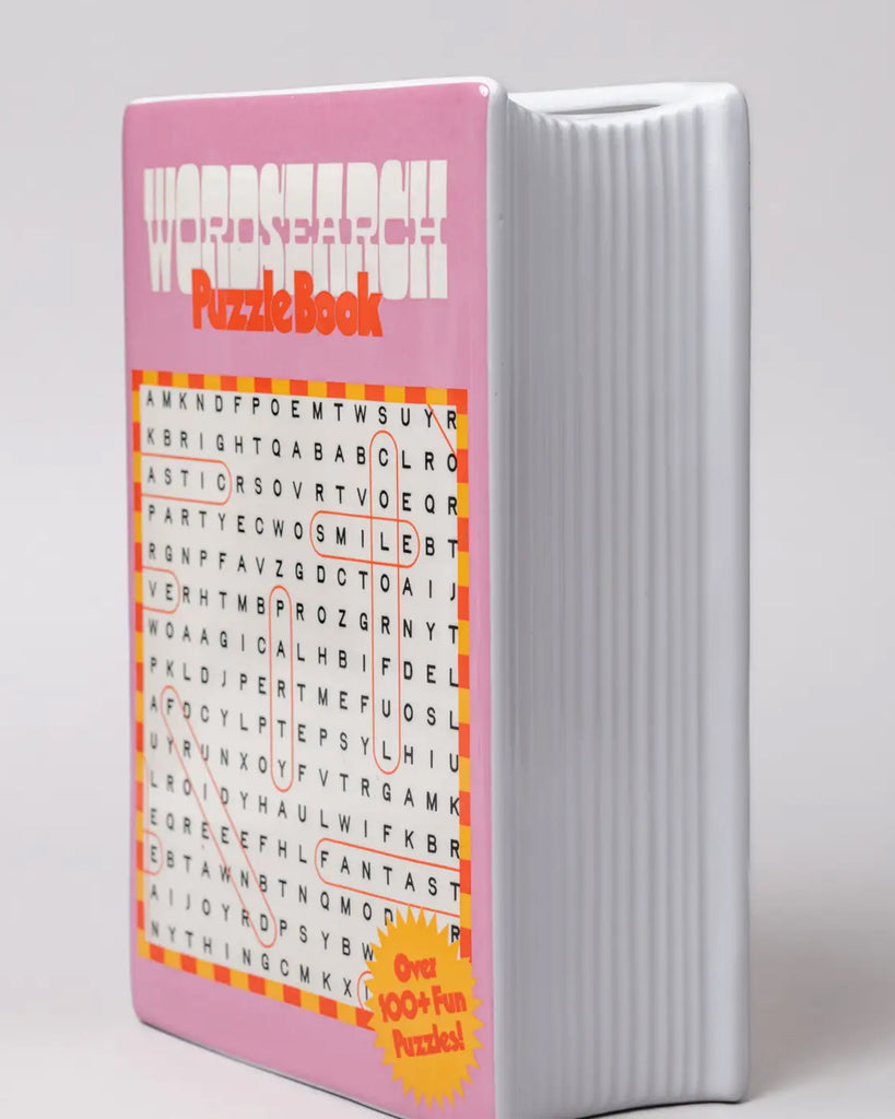 Side angle of the ceramic word search book vase by Rebel Romance, with white ribbed book pages detail and bright pink cover, perfect for quirky home décor lovers.